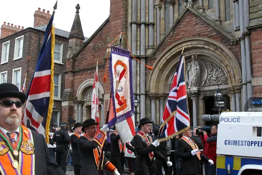 Orangemen march past St.Patrick Catholic Church in north Belfast, Northern Ireland on September 29, 2012. Northern Ireland braced for one of its biggest Protestant parades in years, with police on high alert as pro-British marchers took to the streets of Belfast. Some 30,000 people were expected to join the march marking the 100th anniversary of the Ulster Covenant, a landmark declaration signed by nearly half a million Protestants who vowed to defend themselves against rule from Dublin. AFP PHOTO/ Peter Mu