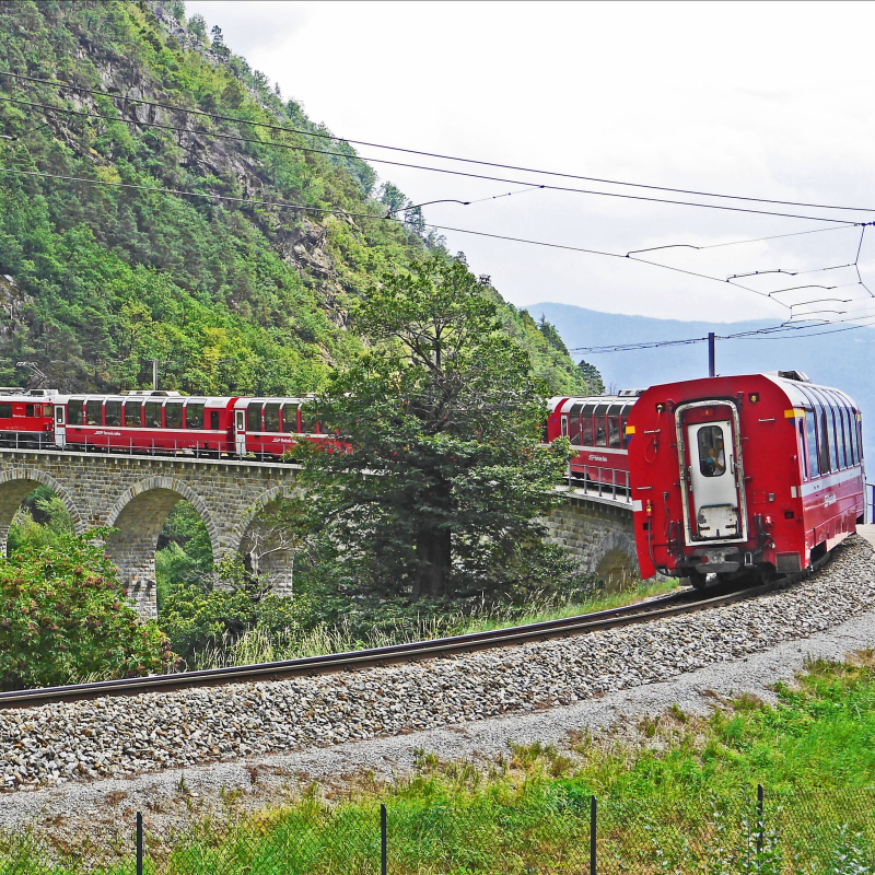 Een rode trein in een bergachtig landschap