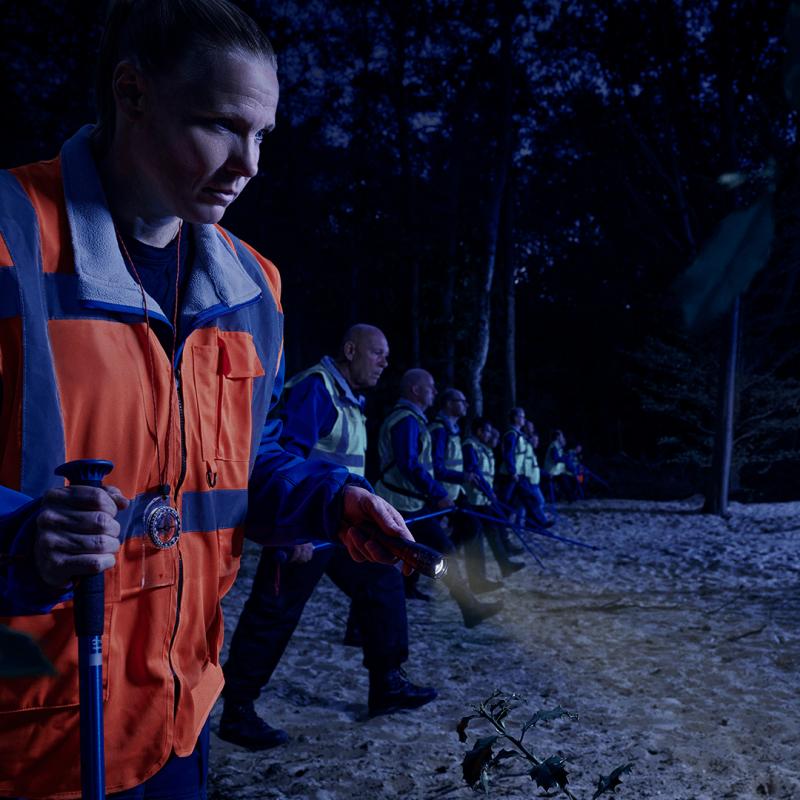 Vrijwilligers van Stichting Veteranen Search Team lopen in linie door bos