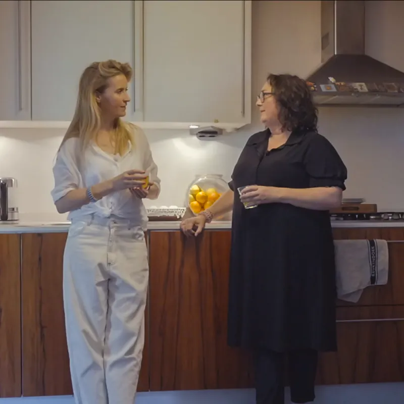 Twee vrouwen praten met elkaar in een keuken