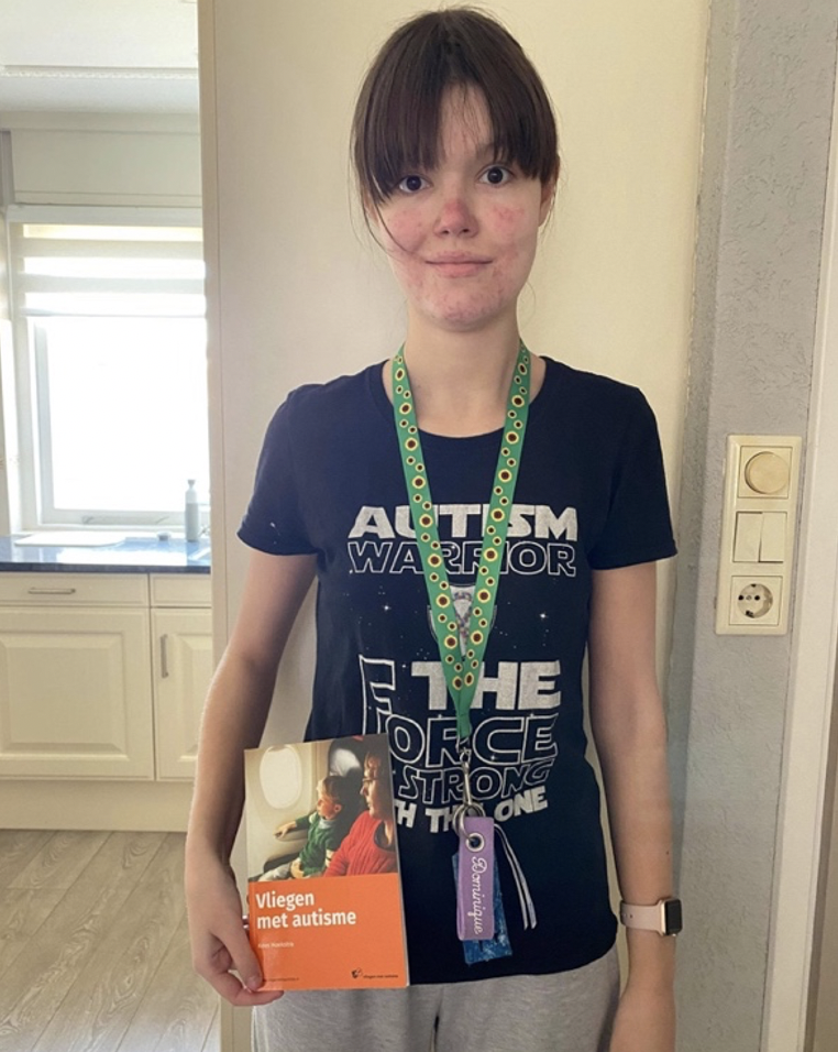 Dominique met haar eigen Sunflower keycord en een boekje van het project ‘Vliegen met autisme’