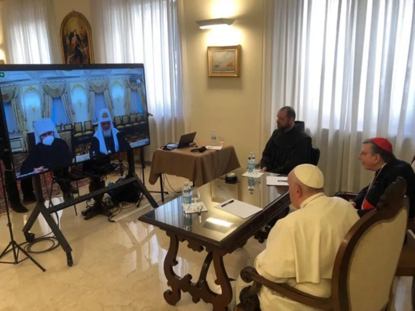 This photo taken and handout on March 16, 2022 by The Vatican Media shows Pope Francis (Front R) talking with Russia's Orthodox Patriarch Kirill (2ndL rear on television screen) during a virtual audience via videolink in The Vatican. The Church "must not use the language of politics, but the language of Jesus", Pope Francis told Russian Orthodox Patriarch Kirill during talks on March 16 about Ukraine, the Vatican said. The head of the Catholic church held a video call with Kirill, a key pillar of President 