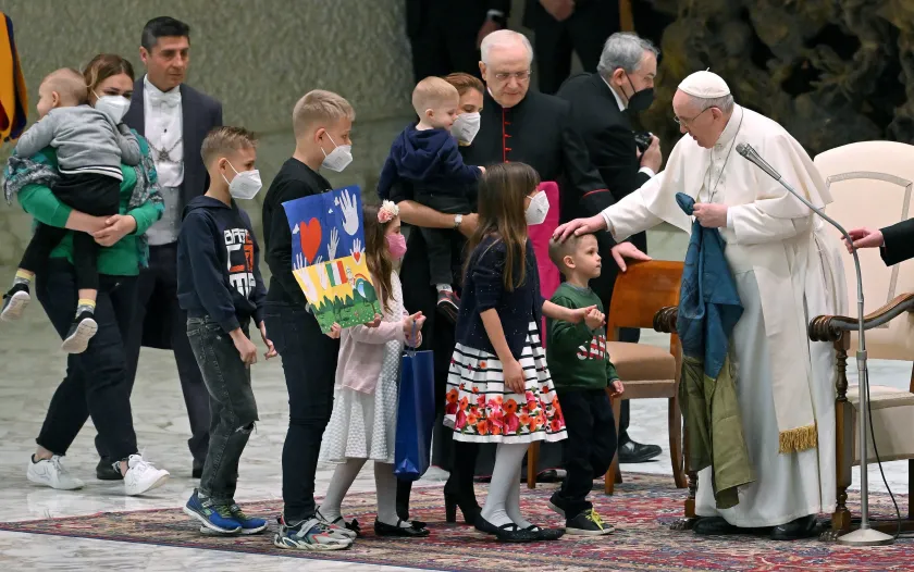 epa09873227 Pope Francis (R) greets Ukrainian children during the weekly general audience in the Paul VI Audience Hall, in Vatican City, 06 April 2022.