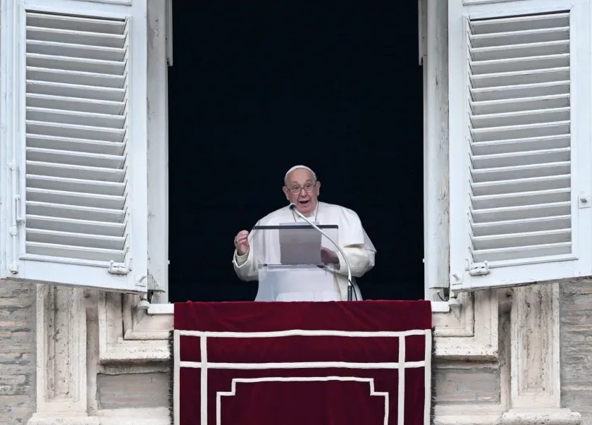 Pope Francis waves to the crowd from the window of the apostolic palace overlooking St Peter's square during the Angelus prayer, at The Vatican on December 26, 2023.  Tiziana FABI / AFP