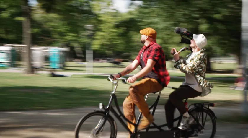 Boswachter Tim en cameraman Sjoerd fietsen op hun tandem