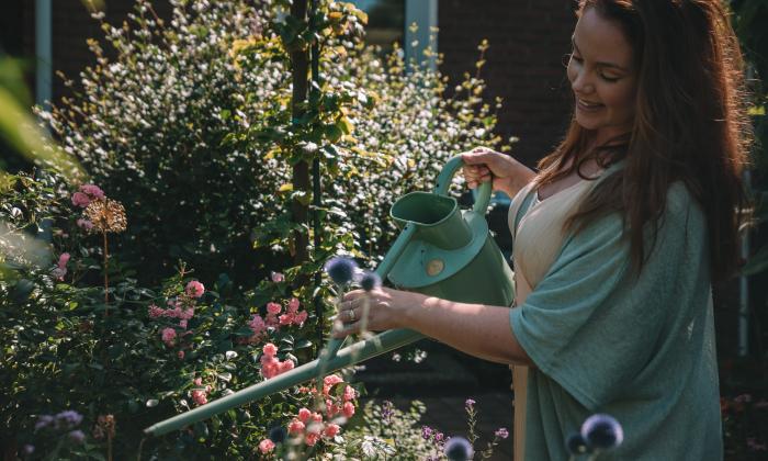 BinnensteBuiten expert Anne Wieggers begiet planten met groene gieter