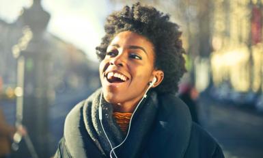 Vrouw luistert naar muziek in de zon